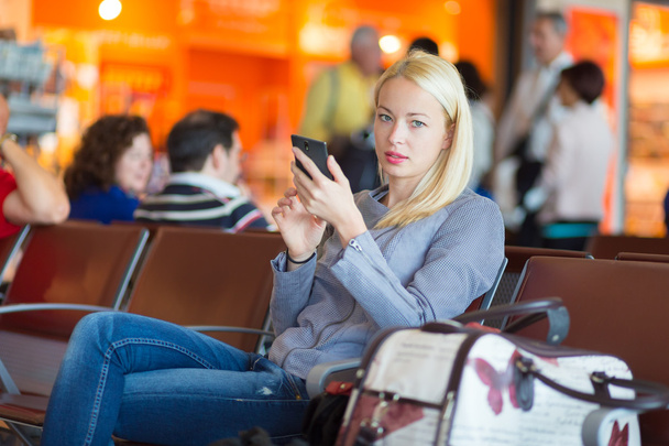 Viajante feminino usando telefone celular enquanto espera
. - Foto, Imagem