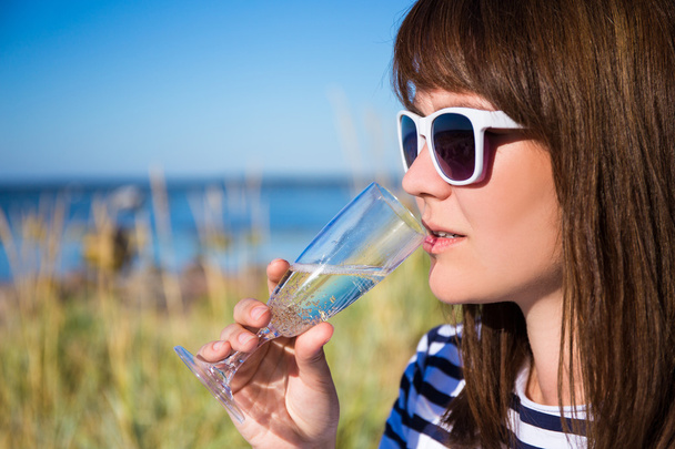 Retrato de hermosa mujer bebiendo champán en la playa - Foto, Imagen