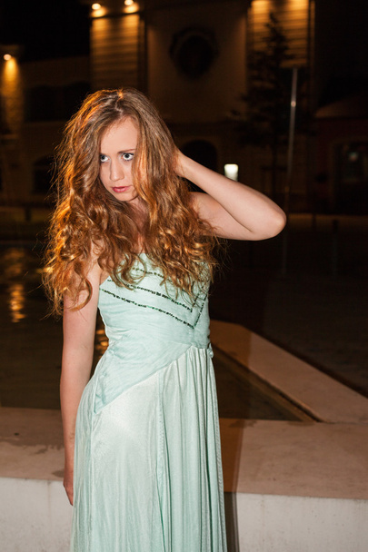 Молода жінка в випускному платті позує на відкритому повітрі вночі
 - Фото, зображення