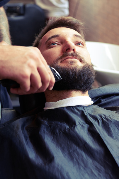 barber shaving beard with electric razor - Photo, image