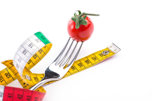 Вилка, томат і вимірювальна стрічка на білому тлі
 - Фото, зображення