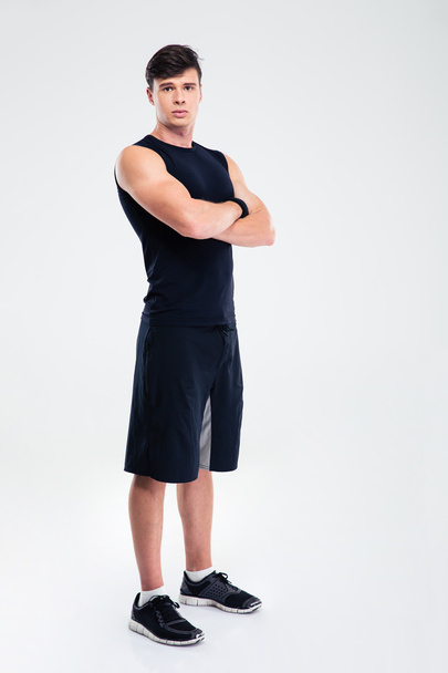 Serious fitness man standing with arms folded - Fotó, kép
