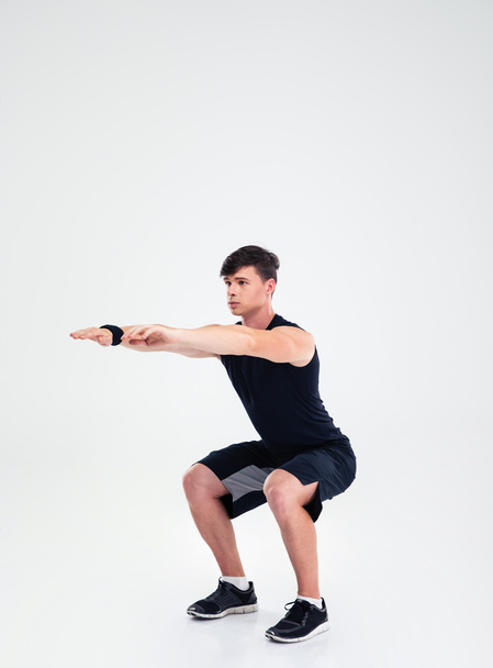 Fitness man doing squatting exercises - Foto, imagen