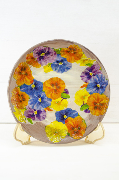 Decoupage plato decorado con patrón de flores contra el coro blanco
 - Foto, imagen
