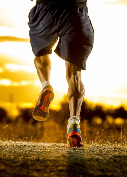 young man strong legs off trail running at amazing summer sunset in sport and healthy lifestyle - Photo, Image