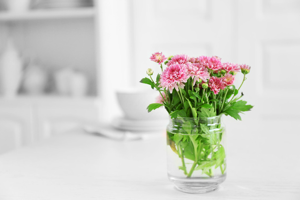 Beautiful flowers in vase on table, on light background - Valokuva, kuva