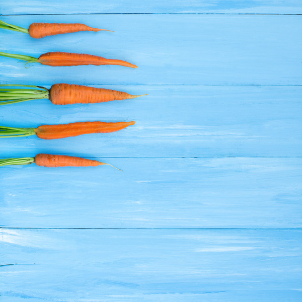 Fresh carrots on blue boards. - Photo, Image