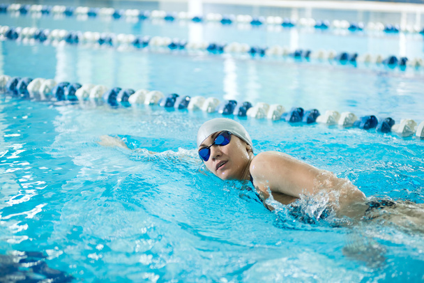 Young girl in goggles swimming front crawl stroke style - Zdjęcie, obraz