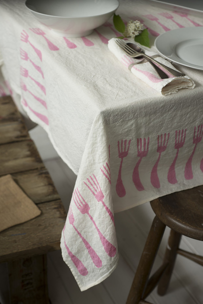 Mantel con diseño de tenedor colocado en la mesa con vajilla
 - Foto, Imagen