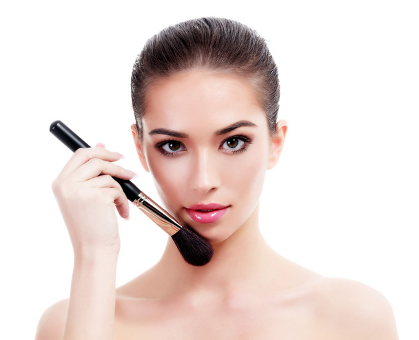 Pretty woman with a makeup brush, isolated on white - Photo, Image