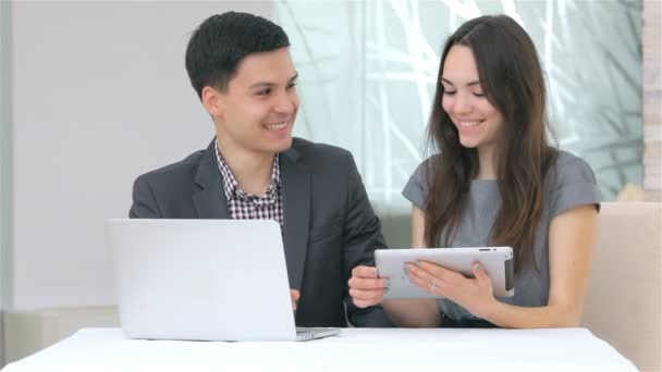 Aantrekkelijke business man en vrouw verzamelen gegevens over de Tablet PC - Video