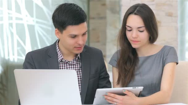 Young business man and woman discussing collating data on the tablet - Séquence, vidéo