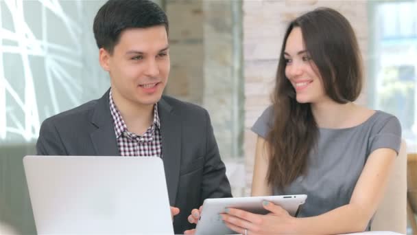 Hombre y mujer de negocios discutiendo la recopilación de datos en la tableta
 - Metraje, vídeo