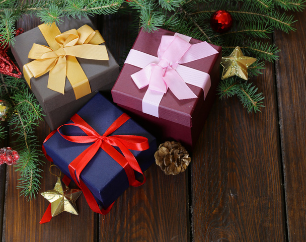 gift boxes with festive ribbons and Christmas decorations on a wooden background - Foto, Imagen