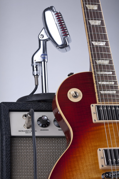sunburst E-Gitarre mit Verstärker und Vintage-Mikrofon - Foto, Bild