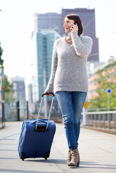 Utazási nőt walking with cellphone és bőrönd - Fotó, kép