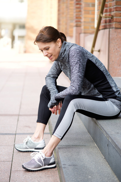 Sportos asszony ül kívül edzés után pihenő - Fotó, kép