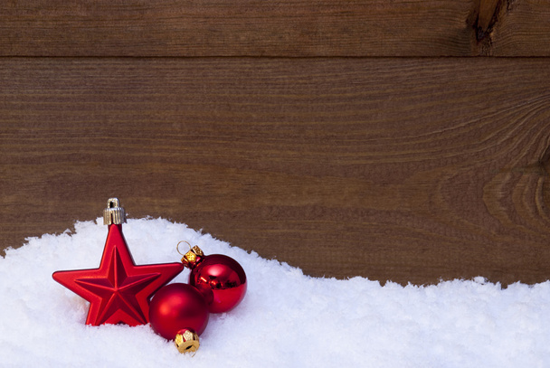 Fundo de Natal de madeira na neve, bolas vermelhas e estrela
 - Foto, Imagem