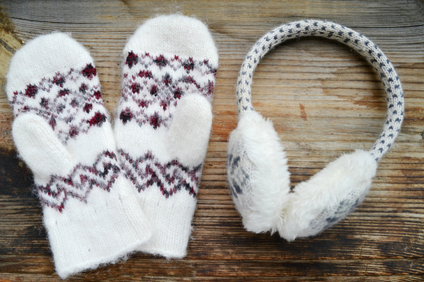 luvas de lã macia com fones de ouvido de inverno na mesa de madeira
 - Foto, Imagem