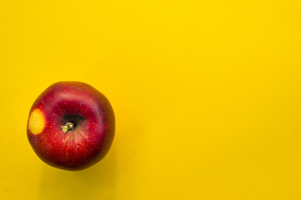 Red apple on yellow background - 写真・画像