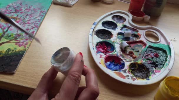 Dívka umělec používá bílé barvy na malování anděl - Záběry, video