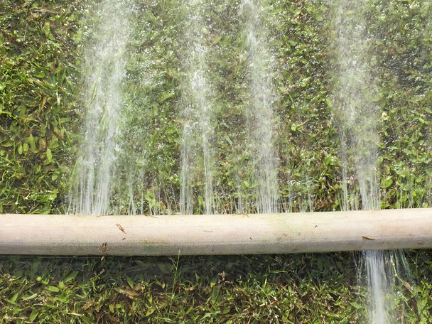 Desperdicio de agua: fugas de agua del orificio de una manguera
 - Foto, imagen