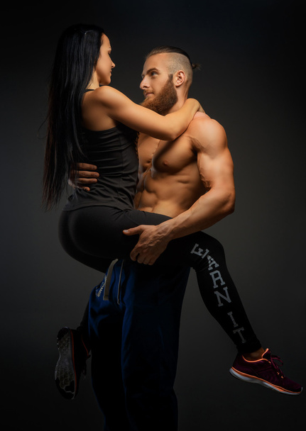 man holding on arms his athletic woman. - Foto, Bild