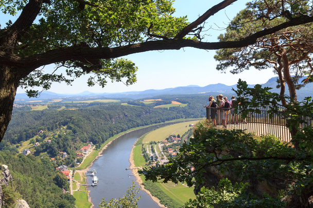 Pessoas em rochas Bastei olhando para o panorama com o rio Elba e Rathen, na Suíça saxã
 - Foto, Imagem