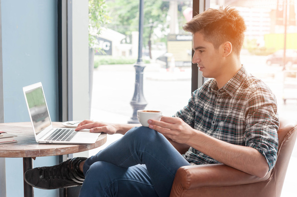 homme buvant du café avec ordinateur portable sur une table en bois dans un café
 - Photo, image