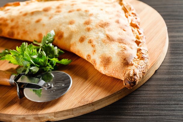 calzone pizza with knife - Foto, immagini