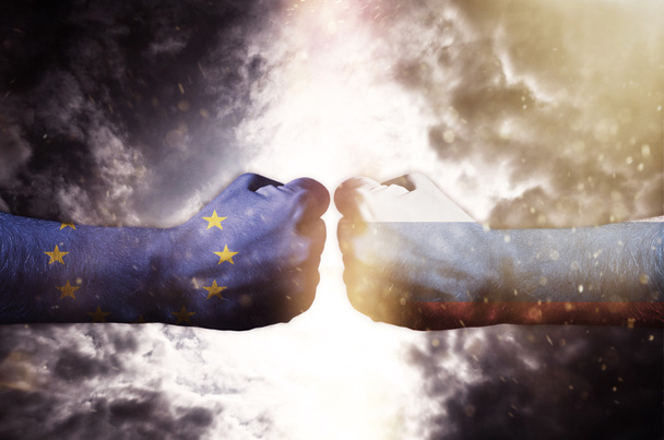 Dois punhos batendo uns nos outros sobre o céu escuro, UE e Rússia conflito
 - Foto, Imagem