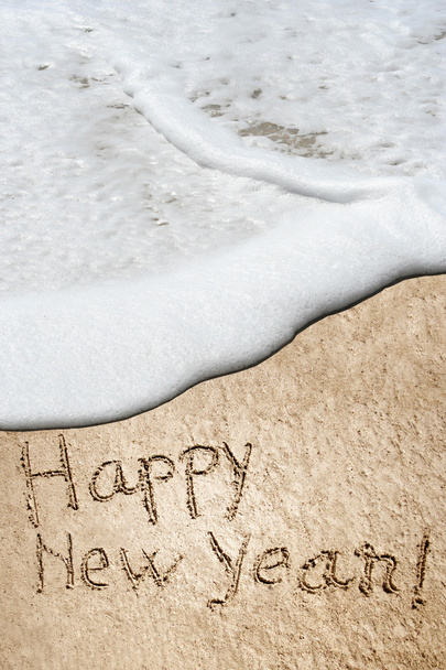 Konzept oder konzeptionelle handgemachte oder handgeschriebene Neujahrstexte in Sand am Strand einer exotischen Insel - Foto, Bild
