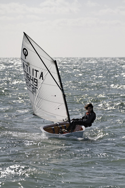 Italy, Sicily, young kid on optimist sailboat - Photo, Image
