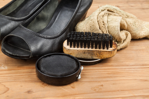 Shoe polish with brush, cloth and worn ladies court shoe on wood - Photo, Image