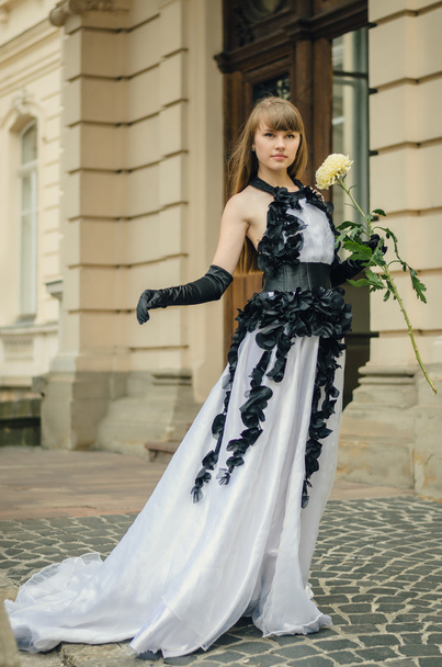 Hermosa joven con vestido blanco con rosas negras permanente b - Foto, imagen