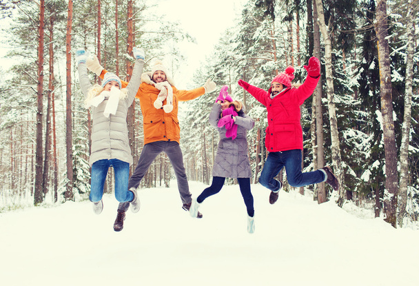 group of smiling men and women in winter forest - Foto, imagen