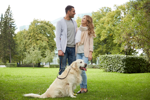 happy couple with labrador dog walking in city - Photo, image