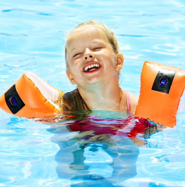 Criança com braçadeiras na piscina
 - Foto, Imagem