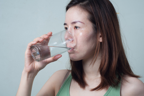 Πορτρέτο της Ασίας γυναίκες σε ένα πράσινο πουκάμισο είναι πόσιμο νερό από - Φωτογραφία, εικόνα