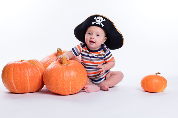 Bebê bonito em uma camiseta listrada e um chapéu de pirata em um branco
 - Foto, Imagem