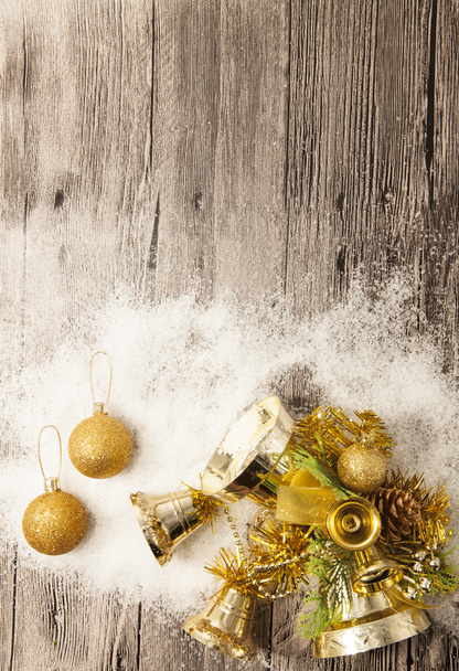 Glittering gold Christmas balls, snowballs, winter snow and star on wooden background - Fotó, kép