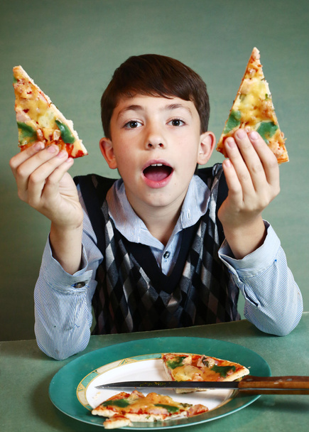 niño con plato de pizza sobre fondo azul
 - Foto, imagen