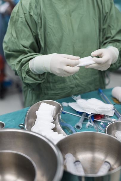 Enfermeira de esfoliação preparar instrumentos médicos para cirurgia cardíaca aberta
 - Foto, Imagem