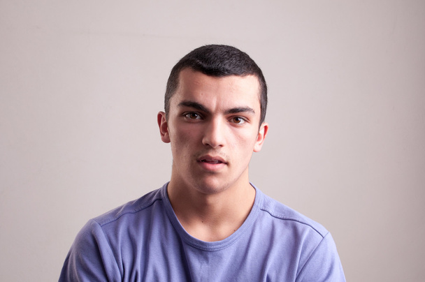 Портрет молодого человека в футболке, смотрящего в камеру
 - Фото, изображение