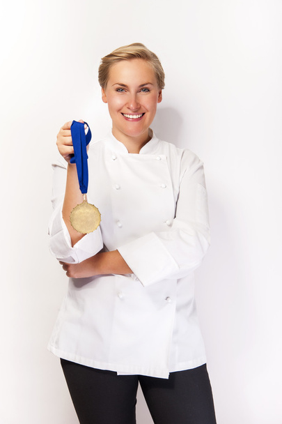 Žena v oblečení kuchaře a první cenu medaile s úsměvem. po bílé b - Fotografie, Obrázek