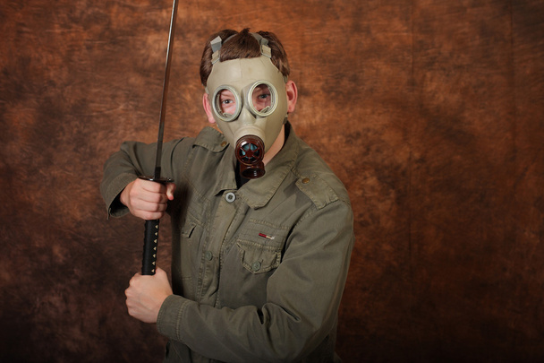 Człowiek z maski gazowe i katana miecz na tle brązowy batik - Zdjęcie, obraz