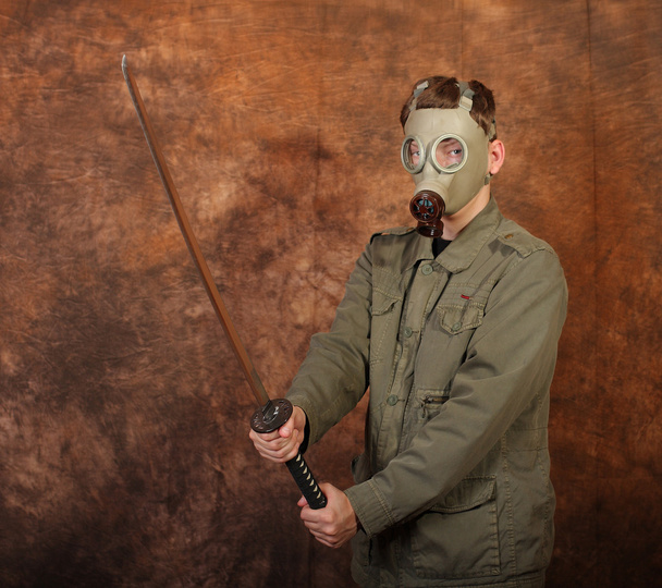 Człowiek z maski gazowe i katana miecz na tle brązowy batik - Zdjęcie, obraz