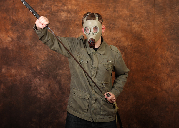 Homem com máscara de gás e espada katana no fundo batik marrom
 - Foto, Imagem