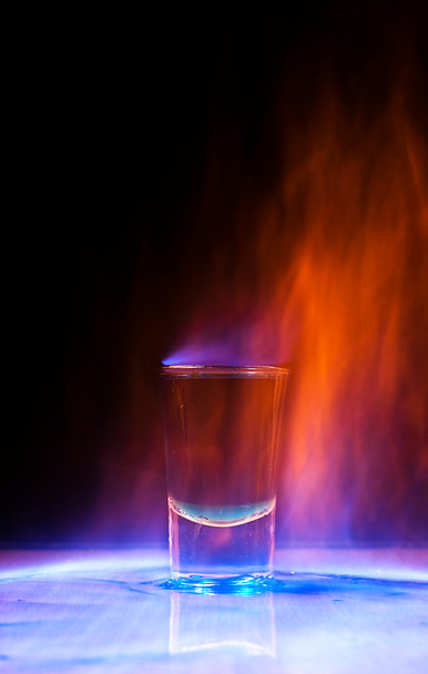 Горящий напиток в рюмке на столе
 - Фото, изображение