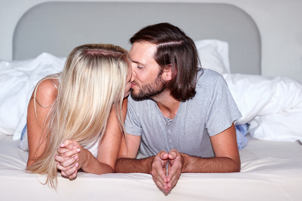 couple kissing on bed - 写真・画像